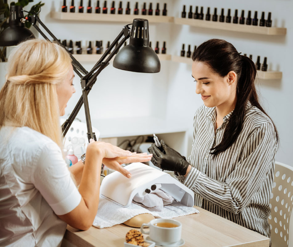 stylistka paznokci wykonuje manicure